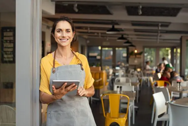 business owner holding tablet and smiling